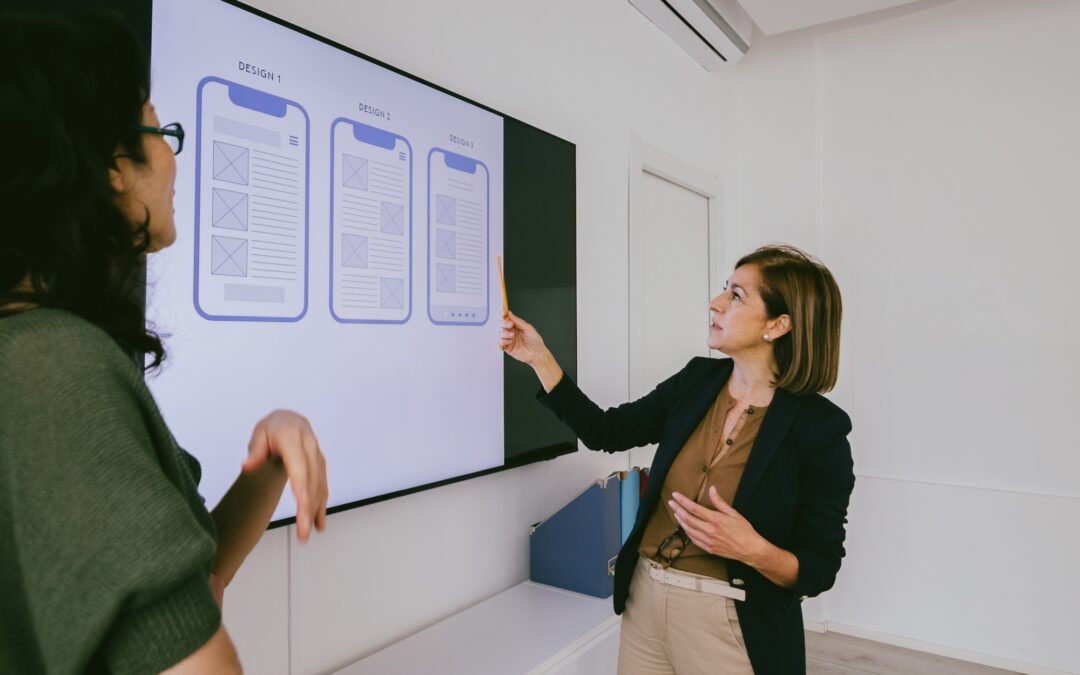 senior businesswoman manager discussing design of presentation layout of app on whiteboard TV